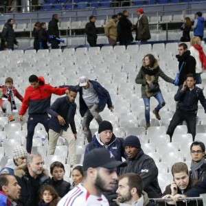 Soccer fans leave the Stade de France stadium after an international friendly soccer match in Saint Denis, outside Paris, Friday, Nov. 13, 2015. An explosion occured outside the stadium. Several dozen people were killed in a series of unprecedented attacks around Paris on Friday, French President Francois Hollande said, announcing that he was closing the country's borders and declaring a state of emergency. (AP Photo/Christophe Ena)