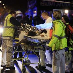 A person is being evacuated from the Bataclan theater after a shooting in Paris, Friday Nov. 13, 2015.  French President Francois Hollande declared a state of emergency and announced that he was closing the country's borders. (AP Photo/Thibault Camus)